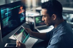 Man looking at a computer in a computer lab.