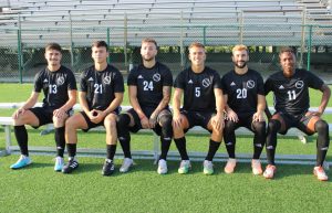 FNU soccer players on bench at Milander Park.