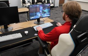 FNU eSports coach Kyler Grotz at a computer playing a game.