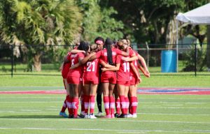 Women's soccer team in a huddle.