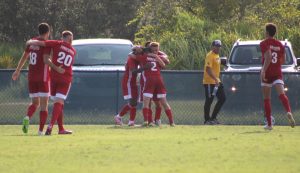 FNU soccer players hugging after scoring a goal.