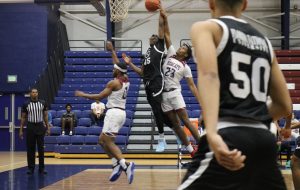 FNU basketball player Matthew Robinson attempting a dunk.