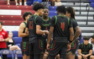 FNU basketball players in a huddle at St. Thomas University.