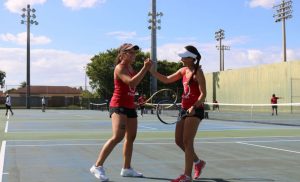 Two women's tennis players high fiving.